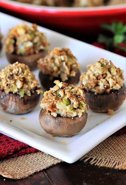 a white platter of stuffing stuffed mushrooms